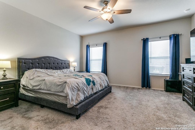 bedroom with a ceiling fan, light carpet, and baseboards