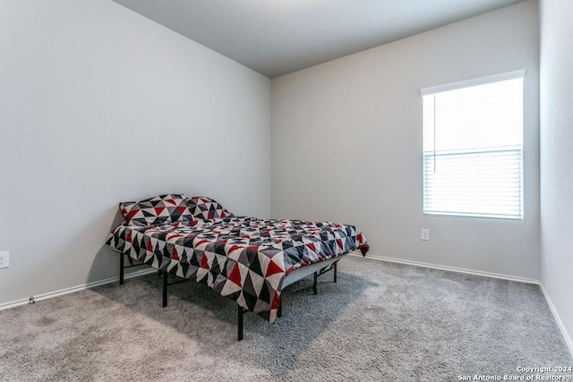 bedroom featuring carpet and baseboards