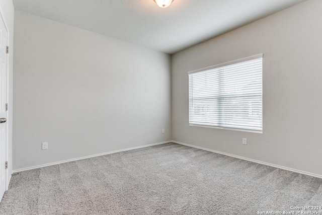 unfurnished room with carpet flooring and baseboards