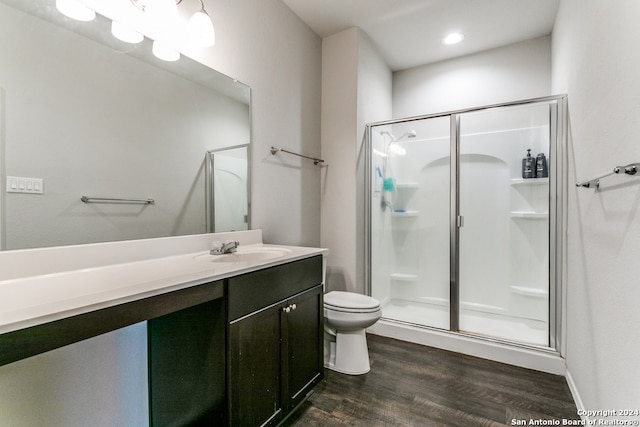 bathroom featuring a shower with door, vanity, toilet, and wood-type flooring