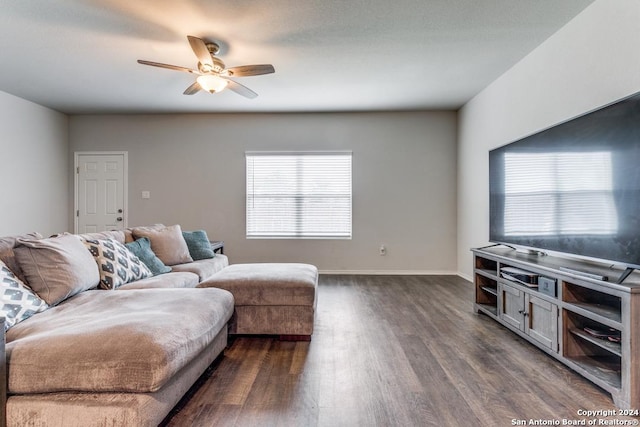 living area featuring dark wood-style floors, baseboards, and a ceiling fan