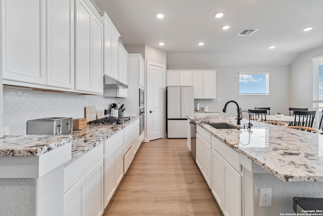 kitchen featuring white cabinetry, light hardwood / wood-style floors, sink, a center island with sink, and stainless steel appliances