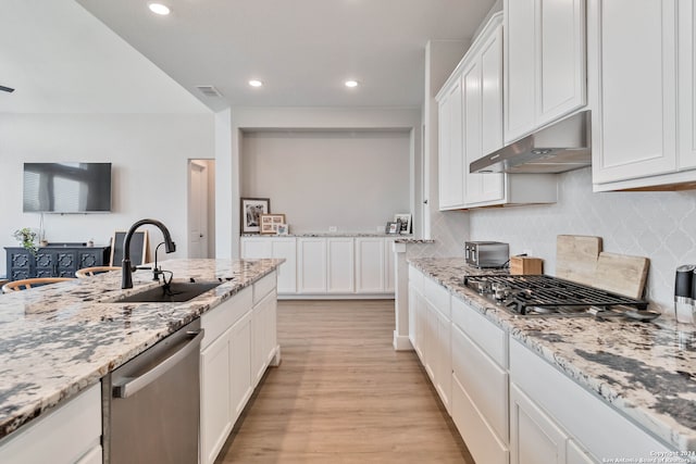 kitchen featuring backsplash, stainless steel appliances, light hardwood / wood-style floors, white cabinetry, and sink