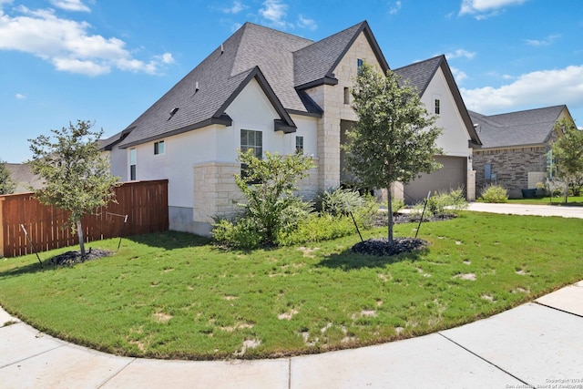 view of front of house featuring a garage and a front lawn