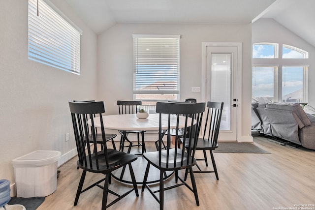 dining room with vaulted ceiling and light wood-type flooring