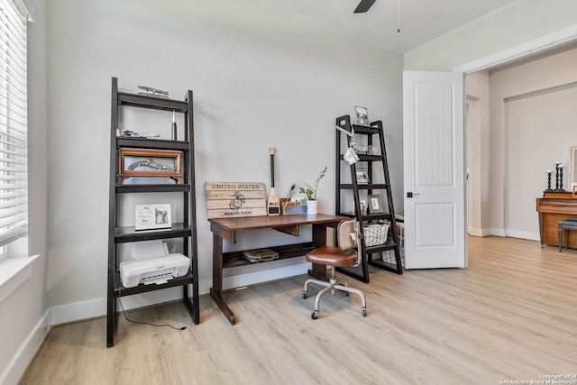 home office with light hardwood / wood-style floors and ceiling fan