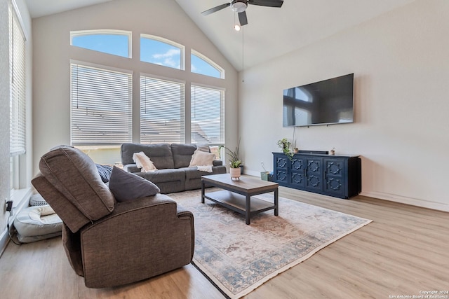 living room featuring high vaulted ceiling, ceiling fan, and light wood-type flooring