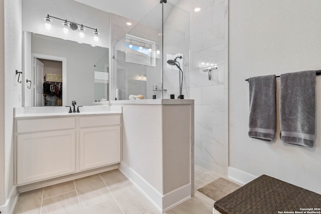 bathroom with tiled shower, tile patterned flooring, and vanity