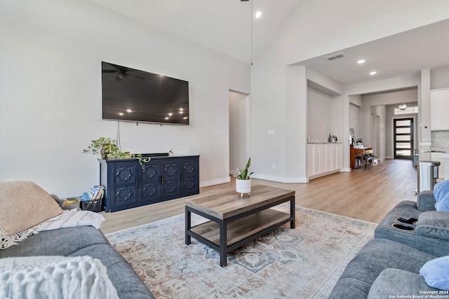 living room featuring light wood-type flooring, high vaulted ceiling, and ceiling fan