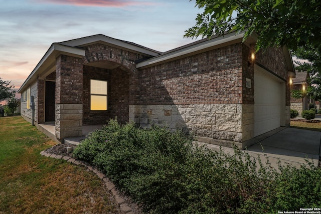 view of front of house with a garage and a lawn