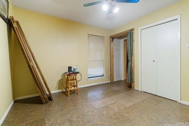 unfurnished bedroom with ceiling fan, a closet, and light tile patterned flooring