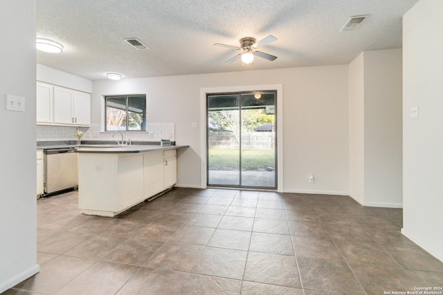 kitchen featuring a peninsula, plenty of natural light, visible vents, and dishwasher