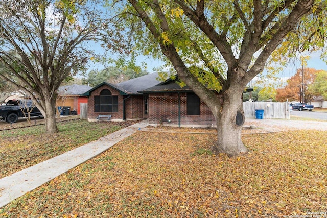 single story home with a front yard, fence, and brick siding