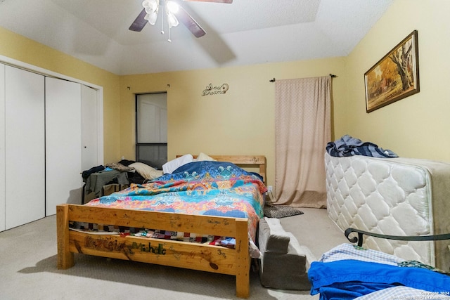 carpeted bedroom with ceiling fan, a textured ceiling, and a closet