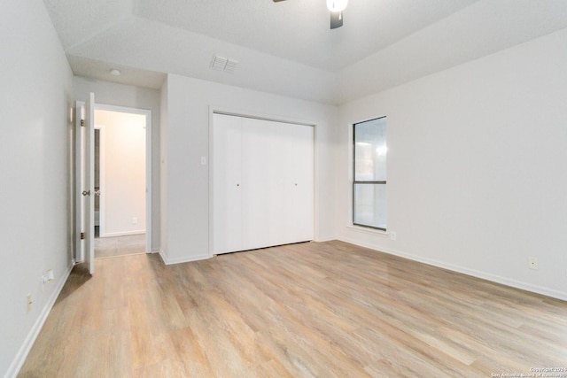 unfurnished bedroom featuring light wood-style floors, baseboards, visible vents, and a closet