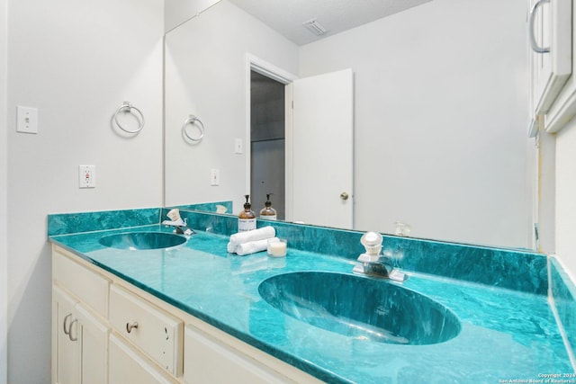 bathroom featuring double vanity, visible vents, and a sink