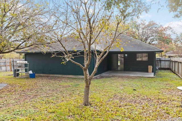 back of house with a patio, a lawn, and a fenced backyard