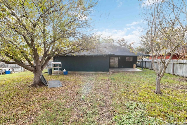 rear view of house featuring a patio area, a yard, and a fenced backyard