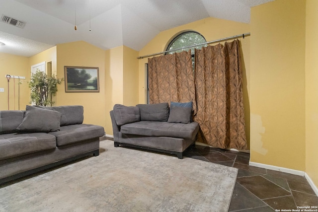 living room featuring lofted ceiling, ceiling fan, and a textured ceiling