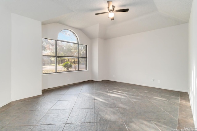 unfurnished room featuring vaulted ceiling, a ceiling fan, and baseboards