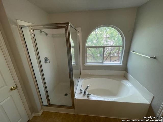 bathroom with hardwood / wood-style flooring and separate shower and tub