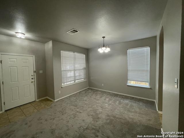 interior space featuring carpet floors, a notable chandelier, and a healthy amount of sunlight