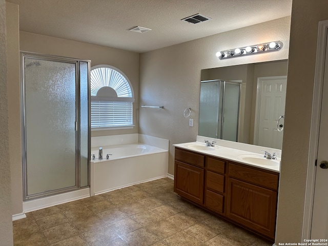 bathroom with a textured ceiling, separate shower and tub, vanity, and tile patterned floors