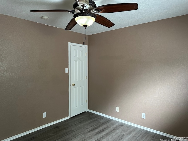 empty room featuring ceiling fan and dark wood-type flooring