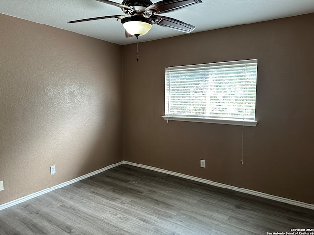 empty room with ceiling fan and hardwood / wood-style floors