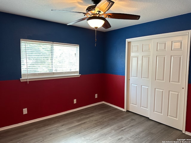 unfurnished bedroom featuring ceiling fan, hardwood / wood-style flooring, and a closet