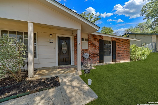 doorway to property featuring a lawn