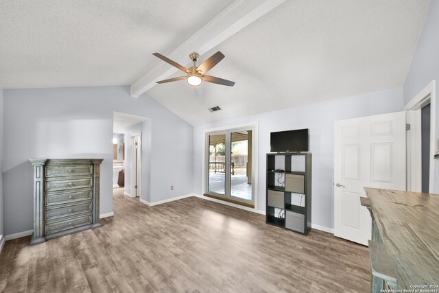 interior space with ceiling fan, a textured ceiling, vaulted ceiling with beams, and dark wood-type flooring