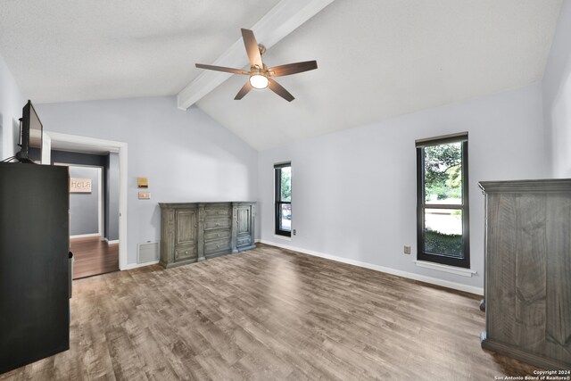 unfurnished living room with ceiling fan, vaulted ceiling with beams, and hardwood / wood-style flooring