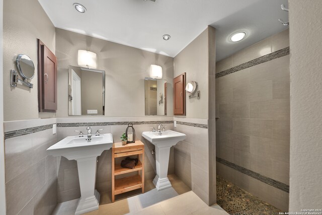 bathroom featuring tiled shower, decorative backsplash, and tile walls