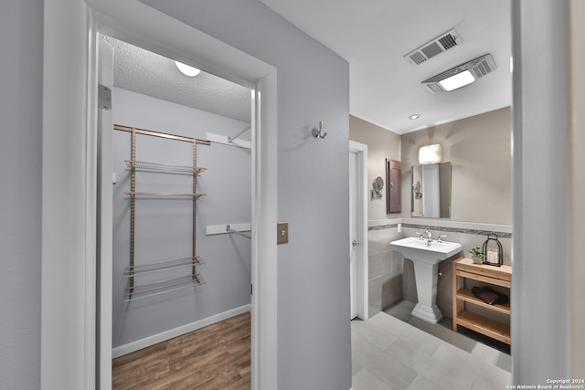 bathroom featuring sink, a textured ceiling, and hardwood / wood-style floors