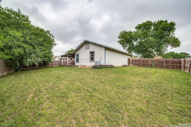 view of yard featuring a wooden deck, central AC, and a fenced backyard