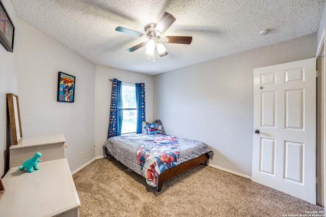 carpeted bedroom with ceiling fan, a textured ceiling, and baseboards