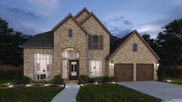 french country inspired facade featuring driveway, a garage, roof with shingles, a front lawn, and brick siding