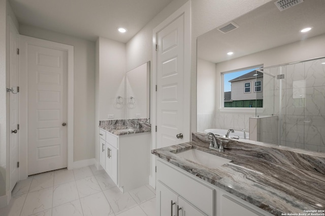 bathroom with vanity and shower with separate bathtub