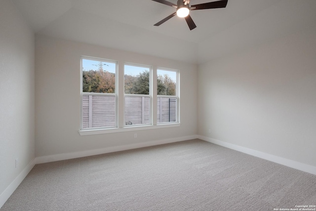 spare room featuring ceiling fan, carpet floors, and vaulted ceiling