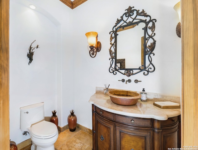 bathroom with tile patterned flooring, toilet, ornamental molding, and vanity