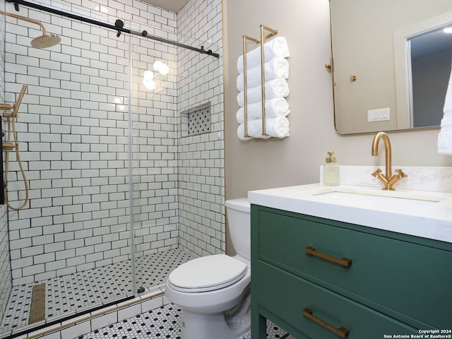 bathroom with vanity, toilet, a shower with shower door, and tile patterned floors