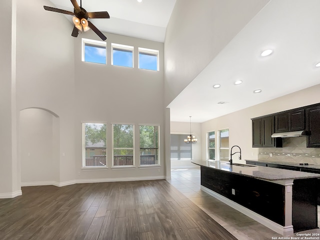 kitchen with ceiling fan with notable chandelier, tasteful backsplash, a healthy amount of sunlight, and sink