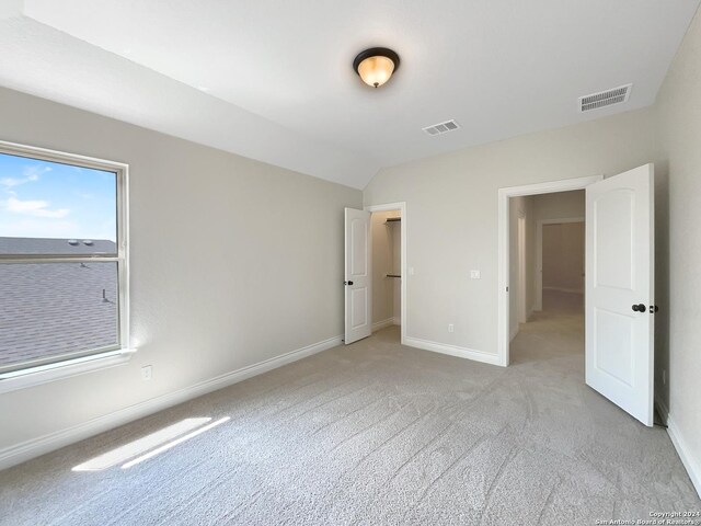 interior space featuring light carpet and vaulted ceiling