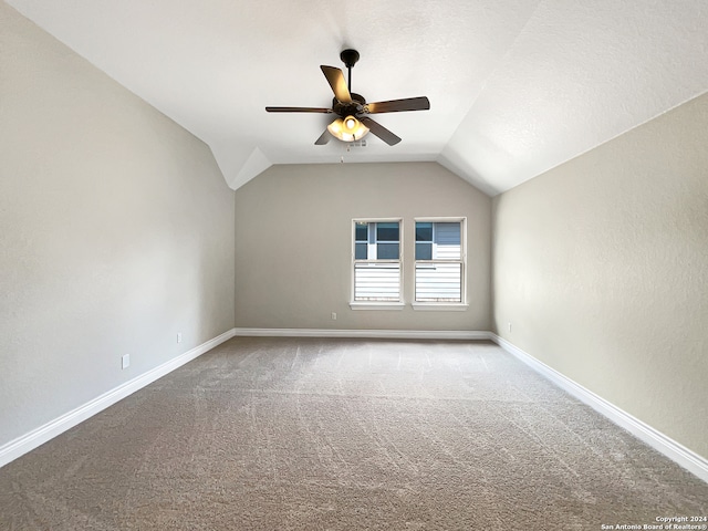 carpeted empty room featuring ceiling fan and vaulted ceiling