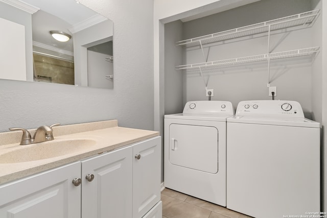 washroom with ornamental molding, washer and dryer, sink, and light tile patterned floors