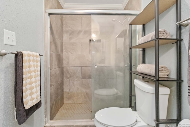 bathroom featuring a shower with door, toilet, and ornamental molding