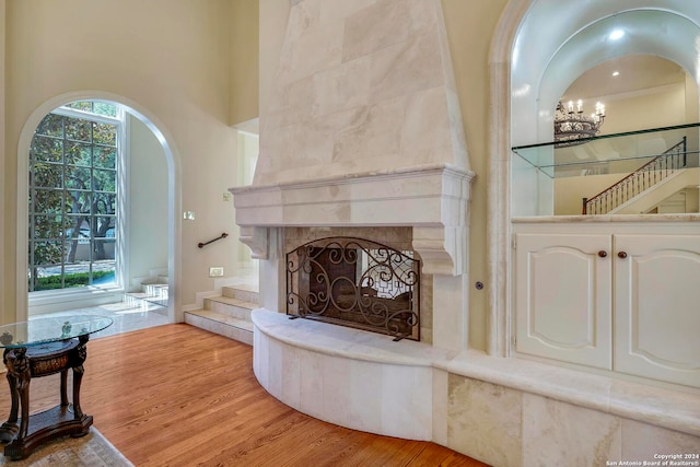 interior space with plenty of natural light, hardwood / wood-style floors, a chandelier, and a tile fireplace