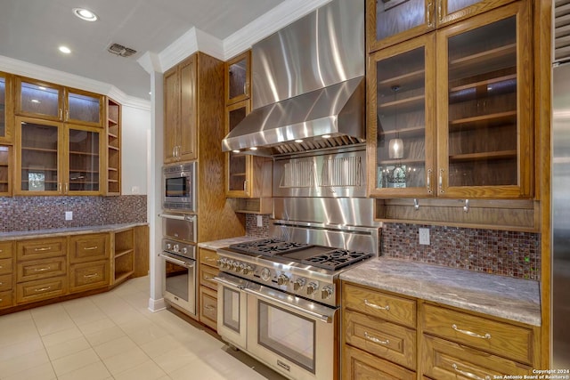 kitchen with light tile patterned flooring, appliances with stainless steel finishes, wall chimney exhaust hood, and tasteful backsplash