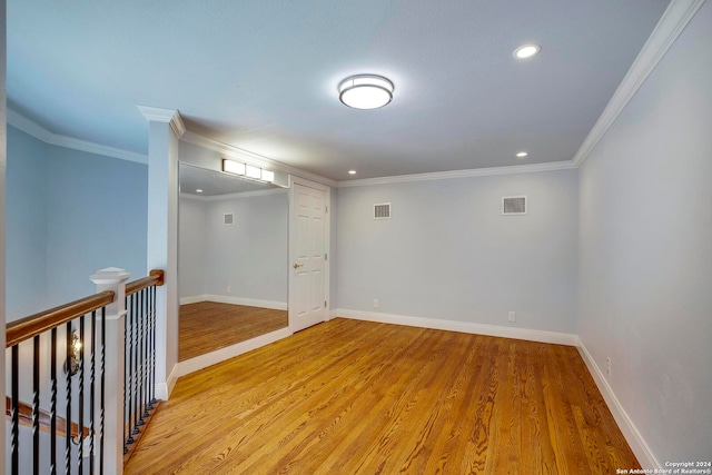 spare room featuring light wood-type flooring and ornamental molding